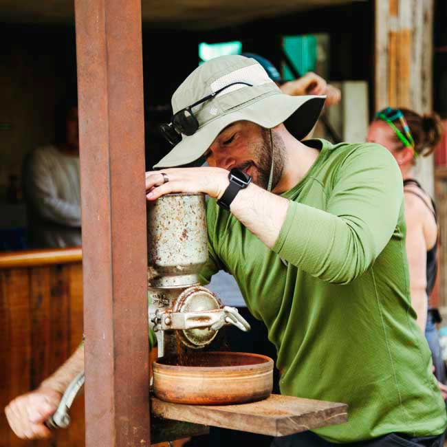 tourist living the experience of grinding coffee on la playa